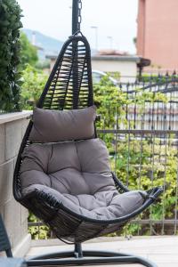 um baloiço de vime com almofadas na varanda em Relax Ciampino - By Good Time Apartments em Ciampino