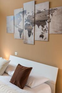 1 dormitorio con 5 pinturas en la pared sobre una cama en Relax Ciampino - By Good Time Apartments en Ciampino