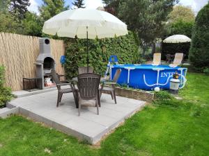 a patio with an umbrella and chairs and a grill at Císařka Apartments in Prague