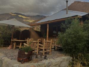 una casa con mesa, sillas y sombrilla en Alcohuaz Indomito, en Alcoguaz