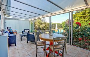 eine abgeschirmte Veranda mit einem Tisch und Stühlen in der Unterkunft Amazing Home In Anneville Sur Mer in Anneville-sur-Mer