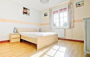 ein Schlafzimmer mit einem Bett und einem Fenster in der Unterkunft Amazing Home In Anneville Sur Mer in Anneville-sur-Mer