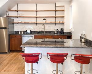 una cocina con barra y taburetes rojos en Beautiful Wooster Sq. getaway - great neighborhood en New Haven