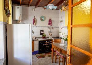 cocina con nevera blanca y mesa en Casa Rural La Aldea en Pola de Laviana