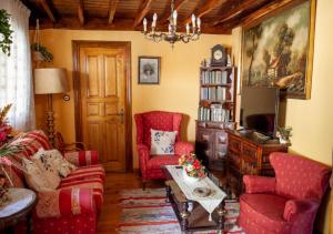 sala de estar con sillas rojas y TV en Casa Rural La Aldea en Pola de Laviana