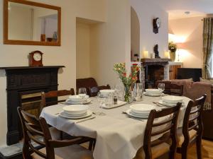 a dining room table with a white table cloth on it at Rhonas Cottage in Abergavenny