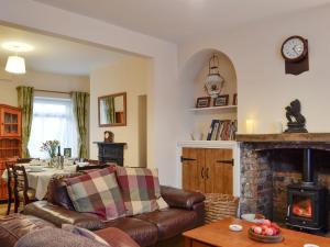 a living room with a couch and a fireplace at Rhonas Cottage in Abergavenny