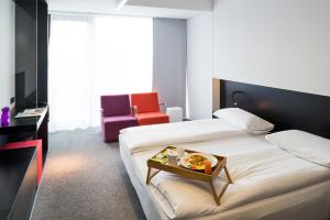 a hotel room with a bed with a tray of food on it at Hotel Privo in Târgu-Mureş