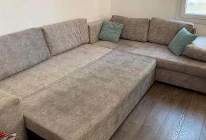 ein braunes Sofa mit zwei Kissen im Wohnzimmer in der Unterkunft Blue Flag Award Winning Ormos Lo Beach: Home 1 in Vrontádos