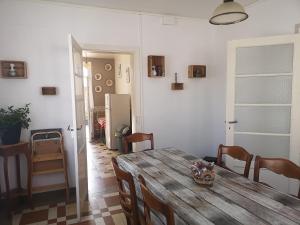 una sala da pranzo con tavolo in legno e una cucina di Le repos bien mérité a Nesle