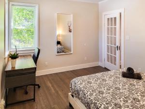 1 dormitorio con cama, tocador y espejo en Beautiful Wooster Sq. getaway - great neighborhood, en New Haven