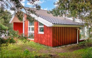 ein rotes Haus mit einem weißen Fenster im Hof in der Unterkunft Strandblick 1 - Dorf 1 in Travemünde