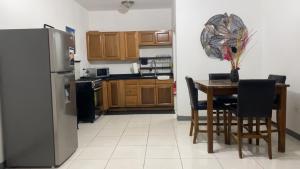 a kitchen with a table and a stainless steel refrigerator at Weekendz- Cozy 2BRD Suite in Port Antonio