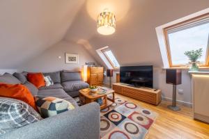 a living room with a couch and a tv at Cartshed Lodge in Hoveton