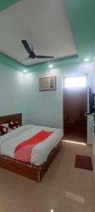 um quarto com uma cama e uma ventoinha de tecto em OYO Hotel Sawan em Meerut