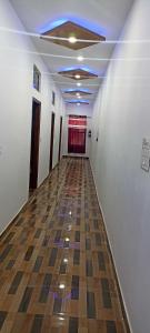 um corredor vazio com piso de madeira e tecto em OYO Hotel Sawan em Meerut