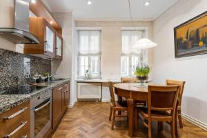 a kitchen with a table and chairs in a room at DICTUMFACTUM Luxury Residence in Tallinn