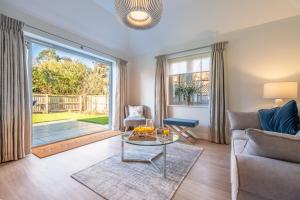 a living room with a couch and a table at Bluebell Cottage in Thornham