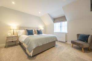 a bedroom with a bed and a chair at Bluebell Cottage in Thornham +49 photos
