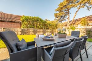 a patio with a table and chairs in a yard at Bluebell Cottage in Thornham