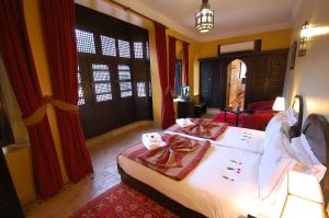 1 dormitorio con 1 cama grande y cortinas rojas en Les Borjs De La Kasbah, en Marrakech