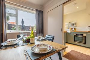 a kitchen and dining room with a wooden table and chairs at 12 The Close in Brancaster