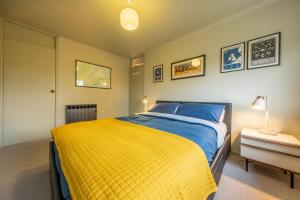 a bedroom with a bed with a yellow blanket at 12 The Close in Brancaster