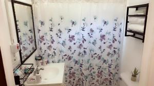 a bathroom with a shower curtain with butterflies on it at Weekendz- Cozy 2BRD Suite in Port Antonio