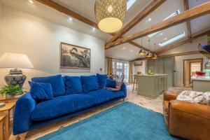 a living room with a blue couch and a blue rug at The Gardeners Cottage E 