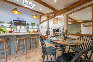 a kitchen and dining room with a table and chairs at The Gardeners Cottage E 