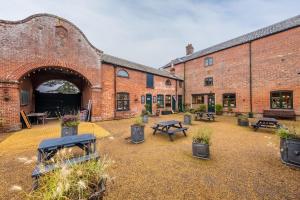 a courtyard with tables and benches in a brick building at The Gardeners Cottage E 