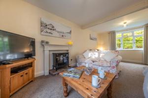 a living room with a couch and a television at Daisy Cottage H in Holt