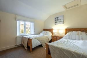 ein Schlafzimmer mit zwei Betten und einem Fenster in der Unterkunft Daisy Cottage H in Holt