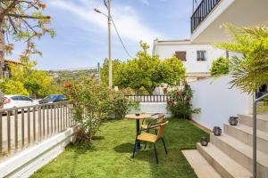 un pequeño jardín con una mesa y sillas en el césped en Stefanos apartment Chania, en La Canea