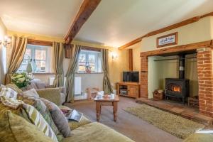 a living room with a couch and a fireplace at Church Cottage CA in Castle Acre