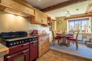 a kitchen with a table and a stove top oven at Church Cottage CA in Castle Acre