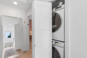 a white laundry room with two washer and dryers at Chris's Sweet Suite - 84 Walkscore in Seattle