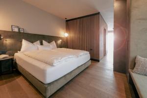 a bedroom with a large white bed in a room at LA LIBELLA - slow living Suites in Merano