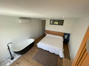 a bathroom with a bath tub and a bed at Olivo de Reis in Caldas de Reis