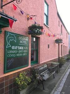 a pink building with a bench in front of it at Dolphin Hotel Public House Weymouth in Weymouth