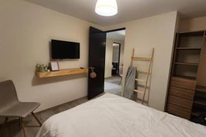 a bedroom with a bed and a tv on the wall at Básico Departamento in Puebla