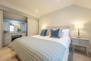 a bedroom with a large bed with blue pillows at Bluebell Cottage 4 in Thornham +39 photos