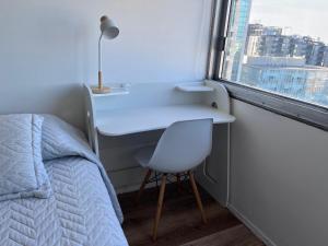 a bedroom with a desk and a bed and a window at Hermoso apartamento en casco histórico con vistas al río in Montevideo