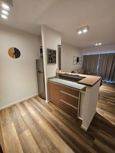 a kitchen with a counter and a refrigerator at Departamento amoblado con balcón y cochera en la entrada de escobar in Belén de Escobar