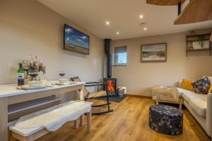 un salon avec une cheminée et un canapé dans l'établissement Bumblebee Cottage, à Barnham