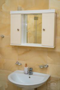 a bathroom with a white sink and a cabinet at Gjiri i Lalzit - Savita Apartments - Kompleksi Turistik Lura 2 in Mullini i Danit