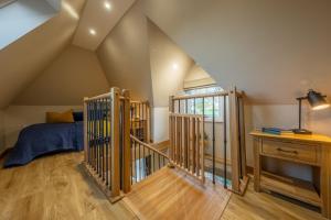 a attic room with a bed and a staircase at Bumblebee Cottage 