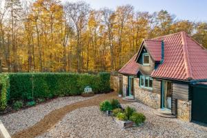 una casa con techo rojo y un cementerio en Bumblebee Cottage 