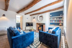 a living room with two blue couches and a fireplace at 154 Blakeney High Street in Blakeney