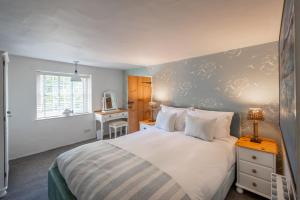 a bedroom with a bed and a desk and a window at 154 Blakeney High Street in Blakeney